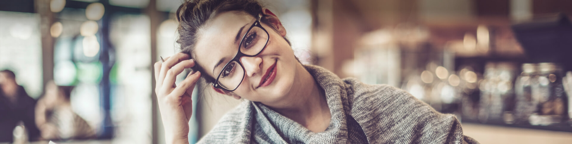 junge Frau mit Brille neigt den Kopf