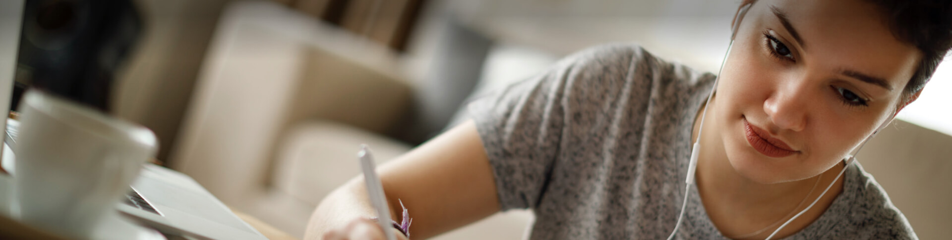 Frau mit In-Ear-Kopfhörern und Stift in der Hand