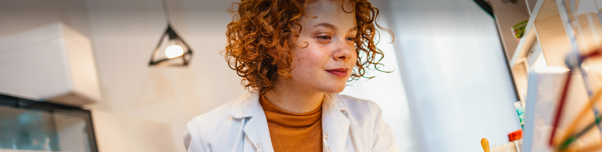 rothaarige Frau mit Locken im Labor